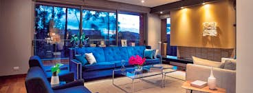 una sala de estar con gabinetes brillantes, muebles, buena ventilación natural