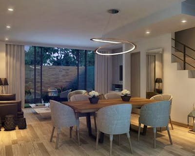 una sala de estar con mesa y lámpara, buena ventilación natural, zona de estar