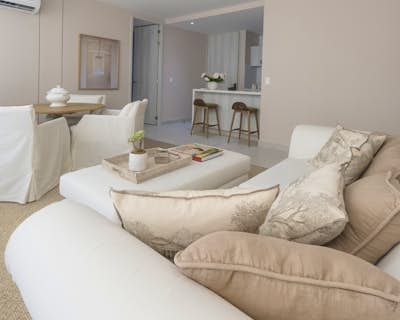 una sala de estar con zona de estar, alfombra de lana, muebles